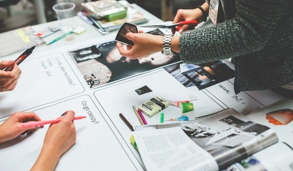 a group of people working on desigining a magazine